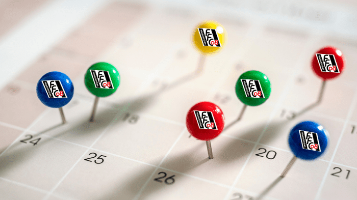 Bunt markierte Pinnadeln mit Vereinslogo stecken in einem Kalender, der verschiedene Termine anzeigt.