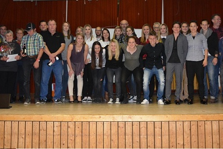 Gruppennahaufnahme von 30 Personen auf einer B&uuml;hne, die gemeinsam bei einer Veranstaltung posieren.