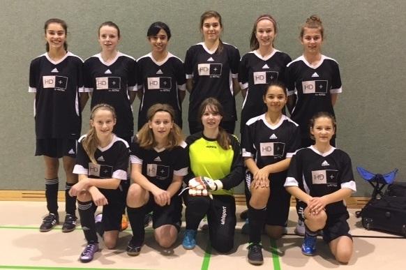 Mannschaftsfoto einer U14-Fu&szlig;ball-Jugendmannschaft in schwarzen Trikots, mit einer Torh&uuml;terin in gelbem Outfit.