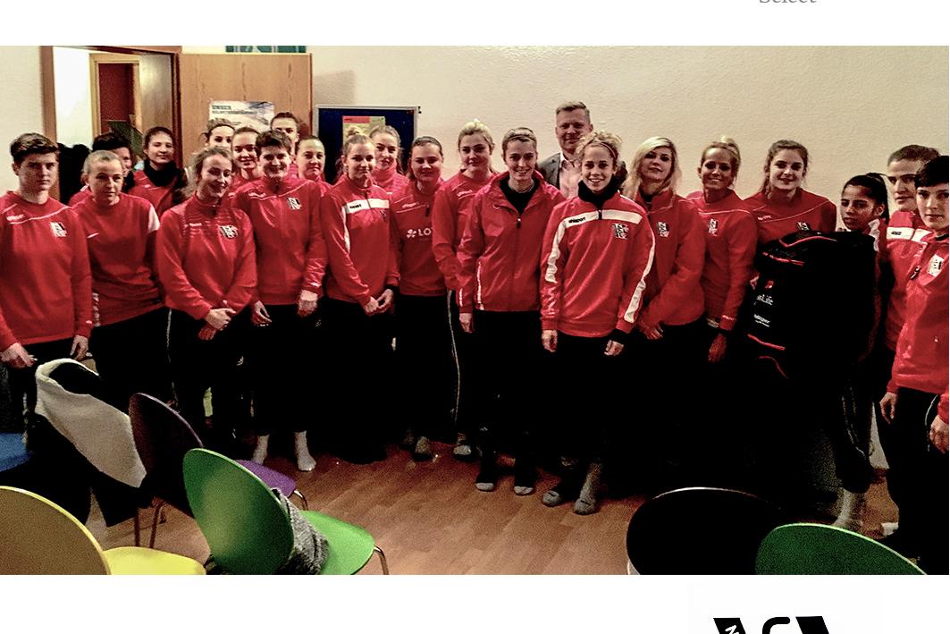 Gruppenfoto des 1. FFC Niederkirchen: Sportler in roten Trainingsanzügen stehen in einem Raum zusammen.