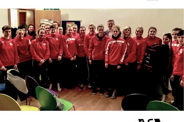 Gruppenfoto des 1. FFC Niederkirchen: Sportler in roten Trainingsanz&uuml;gen stehen in einem Raum zusammen.