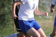 Zwei Fu&szlig;ballspielerinnen im Wettkampf, eine tr&auml;gt ein wei&szlig;es Trikot mit der Nummer 8, die andere ein schwarzes.