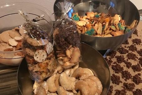 Mehrere Schalen und T&uuml;ten mit verschiedenen Sorten Keksen stehen auf einer Tischplatte.