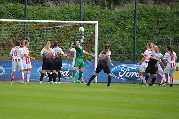 Frauenfu&szlig;ballspiel mit Spielerinnen im Kampf um den Ball vor dem Tor, Torh&uuml;terin wehrt Schuss ab.