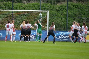 Frauenfu&szlig;ballspiel mit Spielerinnen im Kampf um den Ball vor dem Tor, Torh&uuml;terin wehrt Schuss ab.