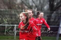 Drei Fu&szlig;ballspielerinnen in roten Trikots laufen auf dem Platz, eine mit Nummer 12.6 im Vordergrund.