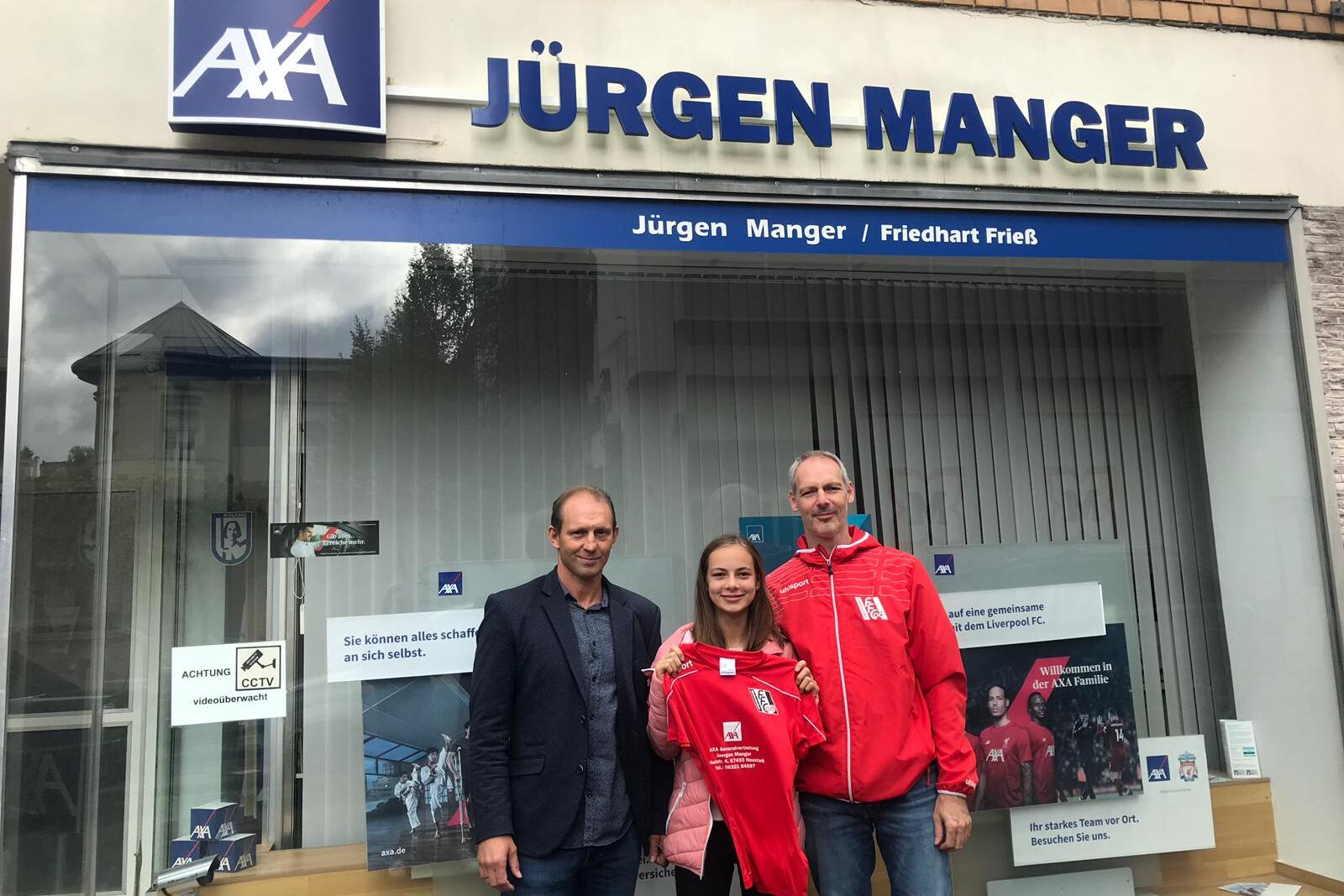 Drei Personen stehen vor einer AXA-Filiale, eine h&auml;lt ein rotes Trikot in der Hand.