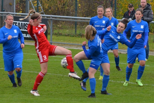 Aktion im Fu&szlig;ballspiel: Spielerinnen in blauen Trikots greifen zwei gegnerische Spielerinnen in roten Trikots an.