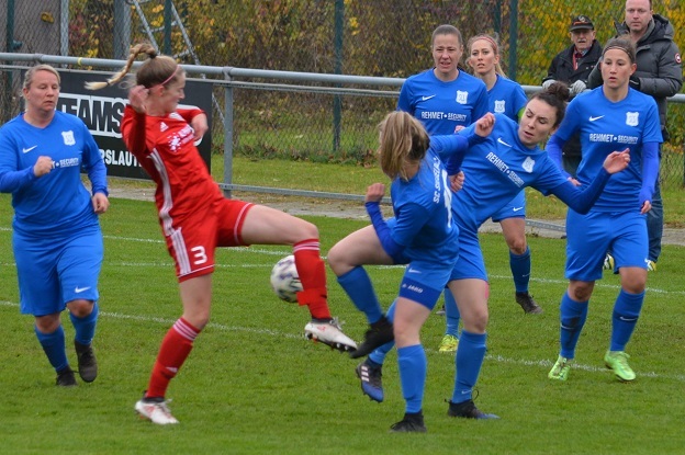 Aktion im Fu&szlig;ballspiel: Spielerinnen in blauen Trikots greifen zwei gegnerische Spielerinnen in roten Trikots an.