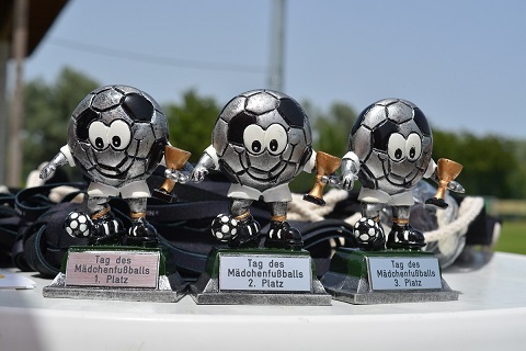 Drei Fu&szlig;ballpokale f&uuml;r Platzierungen bei einem M&auml;dchenspielfest stehen auf einem Tisch.