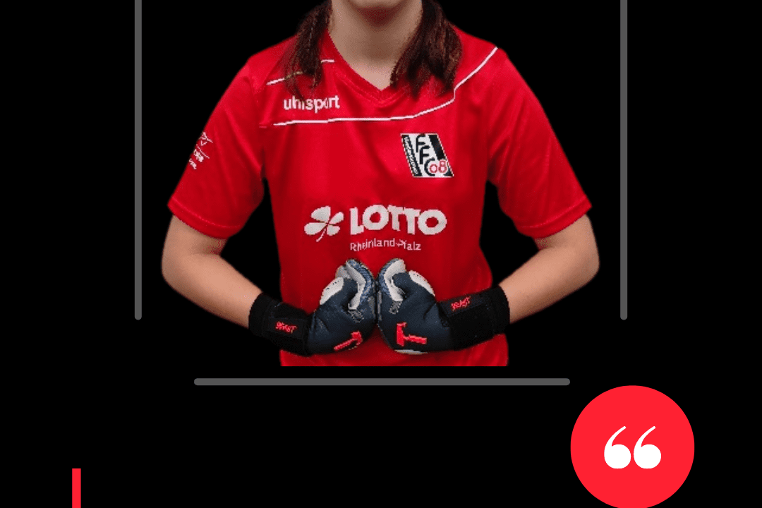 Portr&auml;t einer jungen Fu&szlig;ballspielerin in rotem Trikot mit Handschuhen, pr&auml;sentiert ihre Stellungnahme f&uuml;r das Team 1. FFC Niederkirchen.