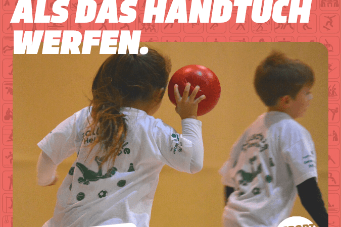 Zwei Kinder werfen einen roten Ball in einer Sporthalle, beide tragen wei&szlig;e T-Shirts mit gr&uuml;nen Aufdrucken.