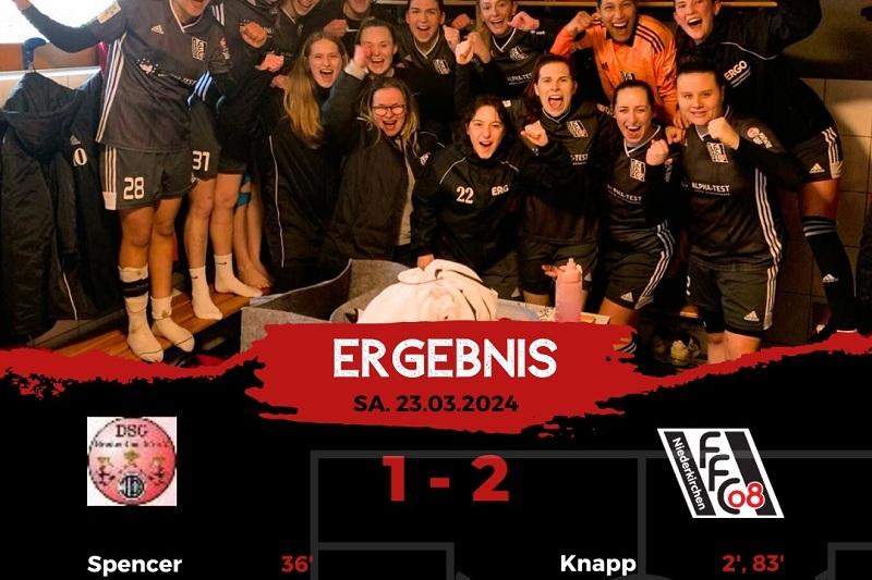 Gruppenshot von Frauenfußballerinnen in schwarzen Trikots, die jubelnd einen Spielgewinn feiern, mit Ergebnis darunter.